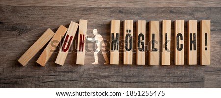 Pieces of wood with the german words for impossible and possible - möglich unmöglich on wooden background