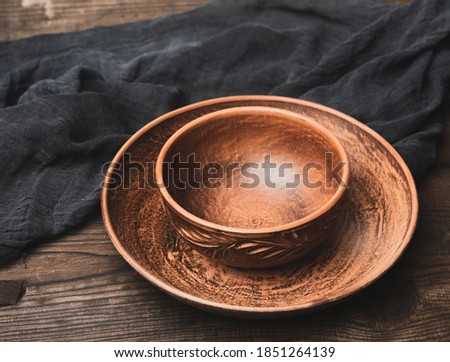 empty brown ceramic plates on a wooden table, top view