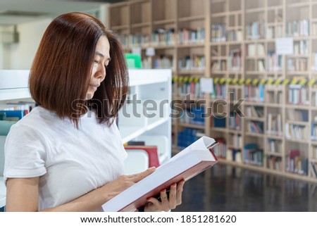 University student reading book in library. Beautiful Asia collage woman study in school campus. Academic education background concept.