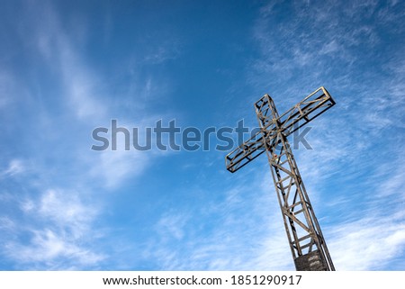 Metal Cross on blue sky with clouds, peak of Corno d'Aquilio, Lessinia Plateau (Altopiano della Lessinia), Regional Natural Park, Verona province, Veneto, Italy, Europe.