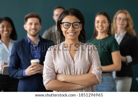 Multiethnic crew. Young biracial female confident qualified specialist hr ceo leader head member of diverse corporate team posing for portrait holding arms crossed on chest smiling looking at camera Royalty-Free Stock Photo #1851296965