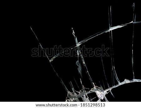 broken mirror and glass from impact on a black background in cracks in the form of an isolated abstraction