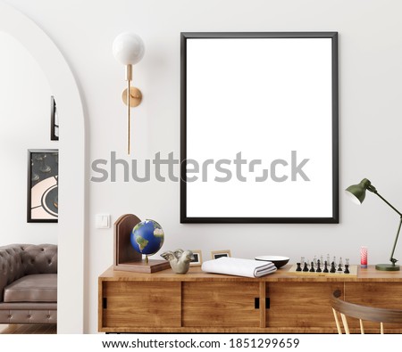 Stylish and eclectic dining room interior with mock up poster map, sharing table design chairs, gold pedant lamp and elegant sofa in second space. White walls, wooden parquet. Tropical leafs in vase. Royalty-Free Stock Photo #1851299659