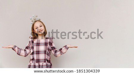 10-year-old girl on a beige background smiling, hands to the sides. High quality photo