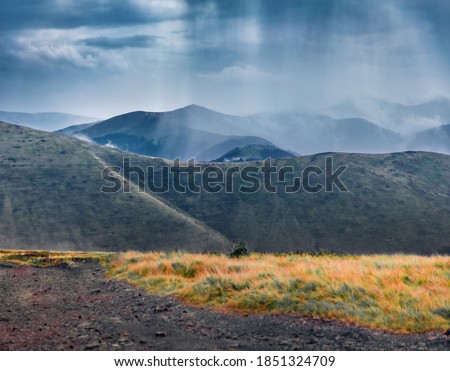 Mountain hills in the rain. Dramatic summer scene of Krasna range with old country road. Gloomy morning view of foggy Carpathian mountains, Ukraine, Europe. 