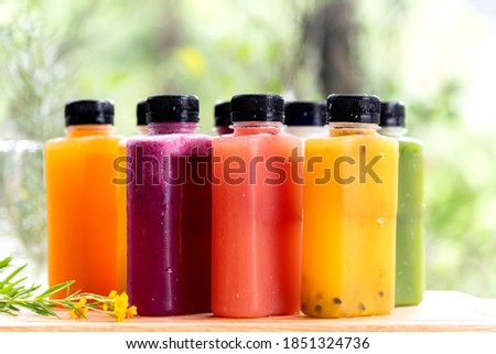 Freshly summer fruit and berries cold press juice serve in grass bottle in ther morning nature background. Royalty-Free Stock Photo #1851324736