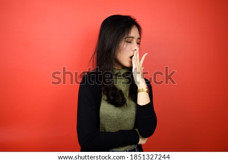 Portrait of Young beautiful asian women using black sweater tired and yawn with red isolated background