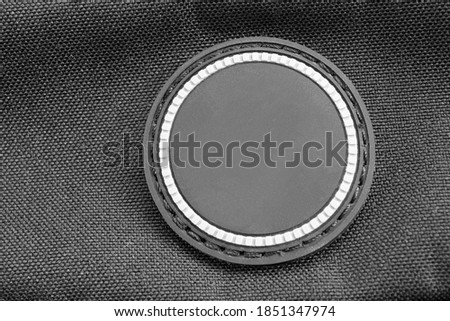 Blank rubber patch on black textile background closeup