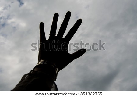 A Silhouette Of Hand In The Cloudy Sky