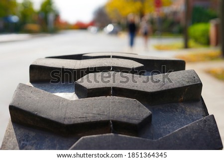 Part of a huge front tire with a large deep tread, sunny day, construction vehicles, Quebec, Canada