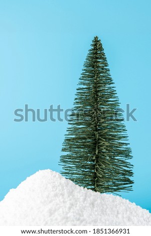 Christmas tree in snow on blue background. Minimal New Year concept.