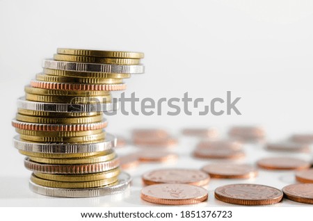 row of coin stack growing pile on white background for money saving and investment business financial and banking concept.