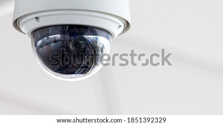 Closeup of white dome type cctv digital security camera installed on ceiling for observation. Royalty-Free Stock Photo #1851392329