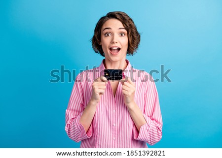 Photo of astonished lady hold credit card scream wow omg wear formal white pink shirt isolated on blue color background