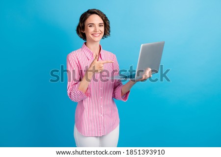 Photo of positive lady point index finger laptop screen wear formal white pink clothes isolated over blue color background