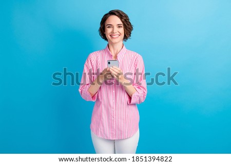 Photo of positive cheerful girl hold cellphone wear formal outfit isolated over blue pastel color background