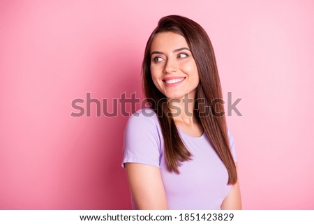 Photo portrait of beautiful female student looking back at blank space smiling isolated on pastel pink color background