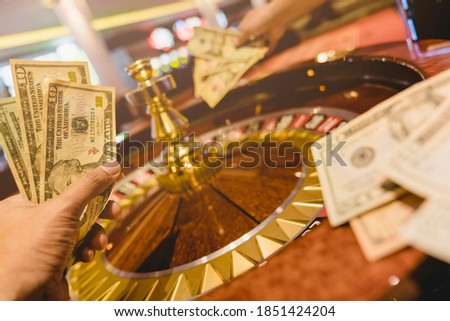 hand hold money bill bet at roulette wheel at casino club gambling game ideas concept