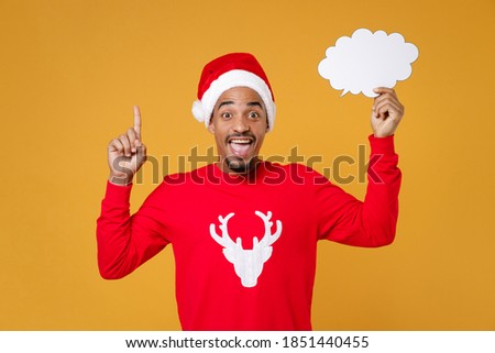 Excited Santa african american man in Christmas hat hold empty blank Say cloud pointing index finger up with great new idea isolated on yellow background. Happy New Year celebration holiday concept