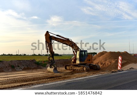 Excavator On Earthworks and Road Construction in City. Temporary Traffic Regulation from carrying out road works or activity on the public highway. Roadway Work Zone Safety. Out of focus, motion blur