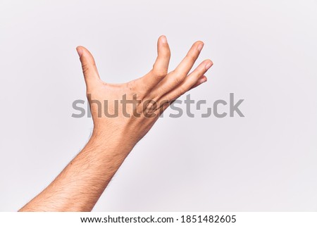 Close up of hand of young caucasian man over isolated background picking and taking invisible thing, holding object with fingers showing space 