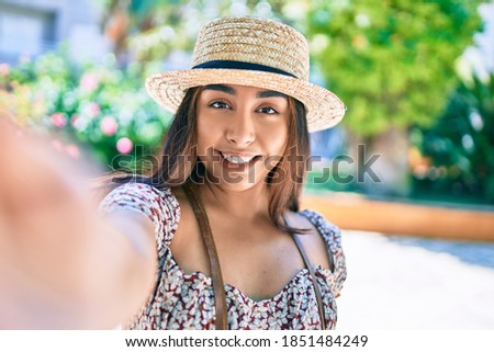 Young latin woman on vacation smiling happy making selfie by the camera at street of city.