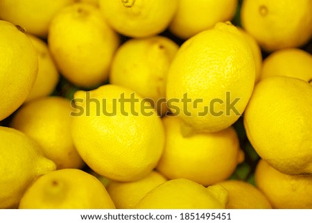 many lemons in one plane lying on top of each other. lemons in the store