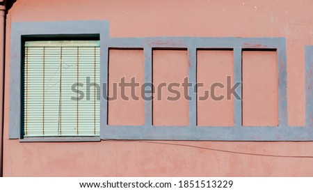 Pink and blue wall and green blind window