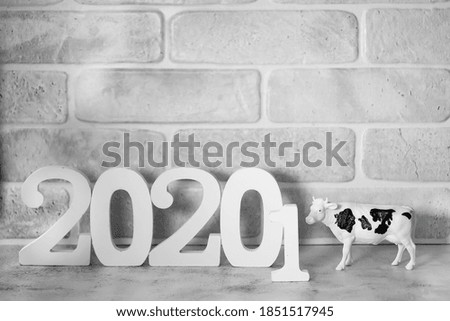 Cow shape and white numbers 2021 on a light gray background. Symbol of 2021 on the Chinese calendar. Christmas and New Years concept. Chinese New Year concept. Soft focus.