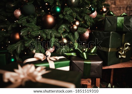 New Year's  gifts lie under the Christmas tree. Large gift boxes are yellow on the floor. Beautiful Christmas tree in  toys.