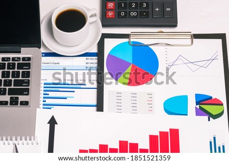 Accountants work desk with computer, cup of coffee, charts and calculator. Analysis of sales reports. Work background, taxes, accounting, statistics and analytical research