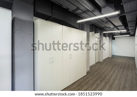 Office corridor. Dark ceiling. Ventilation ducts on the ceiling