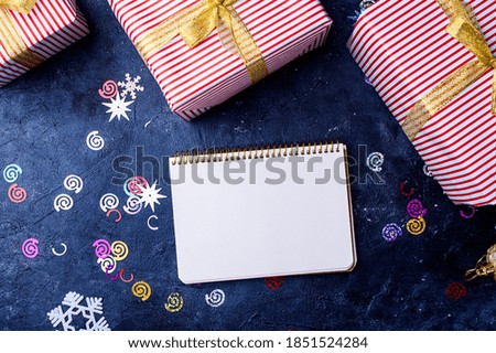 New Year's content with sprigs ate, gold toys for the Christmas tree. gift decorated with gold ribbon, the symbol of the new year 2021. White notebook for text