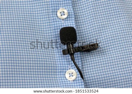 Audio recording of sound on a condenser microphone. The lavalier microphone is secured with a clip on a shirt close-up.