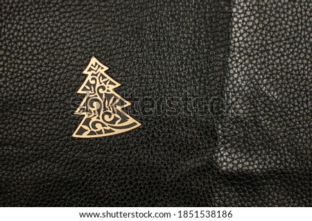 golden Christmas tree on black leather background