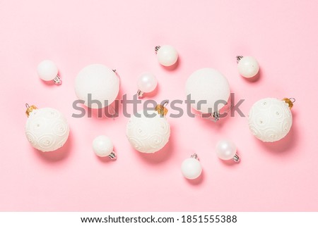 Christmas background with white decorations at pink. Top view with copy space.