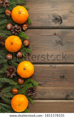 mock up blank for lettering postcard or congratulations. Christmas background - fir branches and cones, hazelnuts, tangerines, Christmas decor on a dark wooden background. empty space