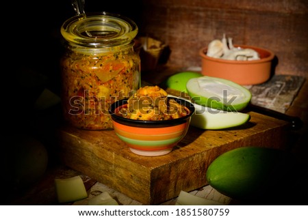 Traditional spicy Punjabi mango pickle on a rustic wooden background selective focus under exposed image 