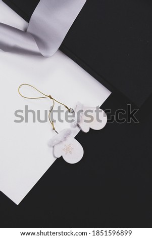 Christmas minimalistic mock up, black and white background, silver ribbon with white wooden scandic toy.