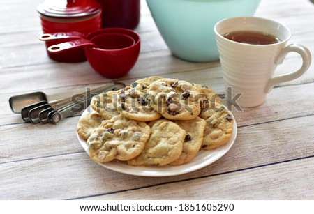 Cosy book and blanket with fresh warm chocolate chip cookies and soothing beverage to enjoy chilly winter days