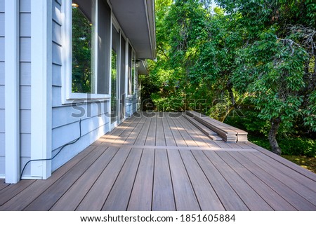Summer construction, outdoor deck under construction, new manufactured wood planks installed
 Royalty-Free Stock Photo #1851605884