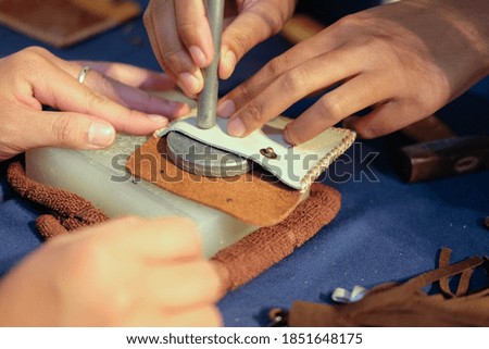 craftsman pinching button on leather bag. handmade DIY handicraft workshop