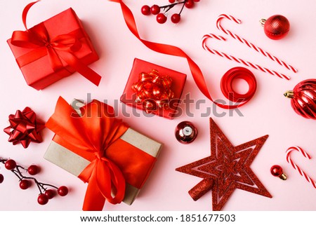 Christmas red presents and decoration on pink background. New Year greeting card. Flat lay, top view.