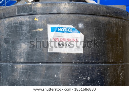 Notice On Large Industrial Black Plastic Water Tank Indicating Non Drinking Water. Stock Photograph.
