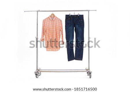 plaid shirt checkered with black jeans hanging on hangers on a white background


