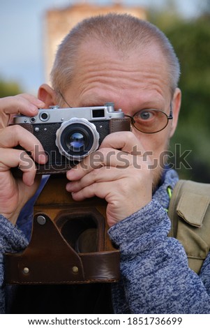 photographer with old style camera looking at camera taking shot