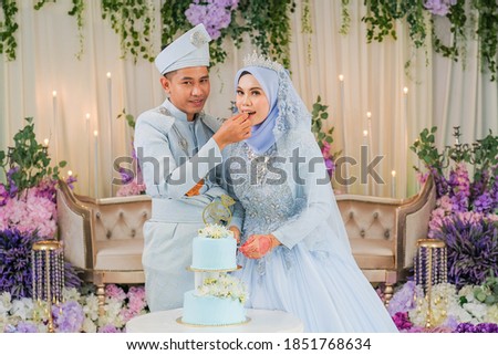 Malaysian wedding couple having a slice of cake after their reception event