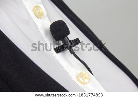 clip-on lavalier microphone is attached to women's clothing close-up. Audio recording of the sound of the voice on a condenser microphone