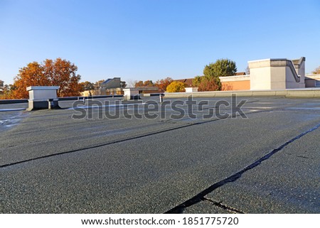 Building with newly renovated flat roof sealing Royalty-Free Stock Photo #1851775720