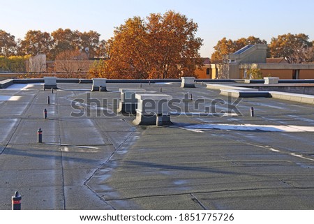 Building with newly renovated flat roof sealing Royalty-Free Stock Photo #1851775726